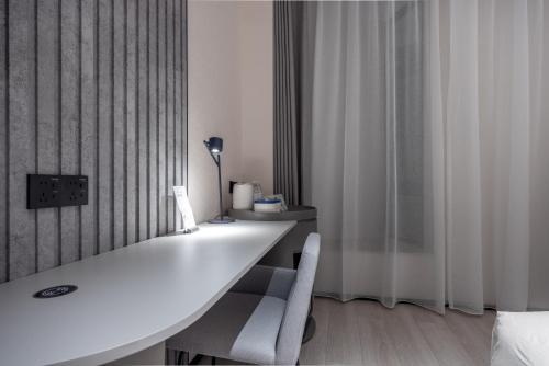 a room with a white desk with two white chairs at Atour Light Hotel Shenzhen North Railway Station Subway Station in Shenzhen