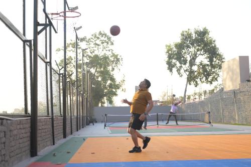a man throwing a basketball on a basketball court at Clarks Safari Haridwar in Haridwār
