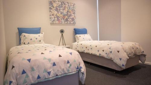 a bedroom with two beds and a painting on the wall at St Andrews Beach Golf Club Apartment 8 03 in Fingal