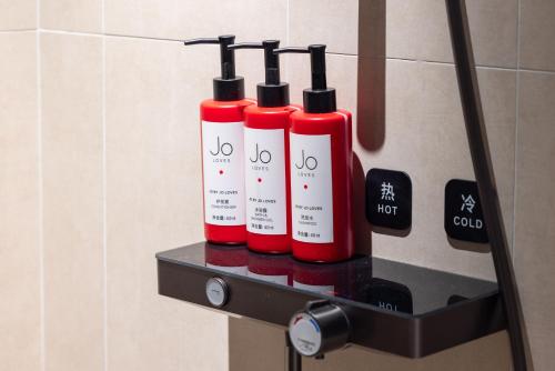 a group of four bottles on a shelf in a bathroom at Atour Light Hotel Shenzhen North Railway Station Subway Station in Shenzhen