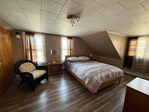 Un dormitorio con una cama y una silla dentro. en Cabin Perfect for Nature Lovers, en Stephentown