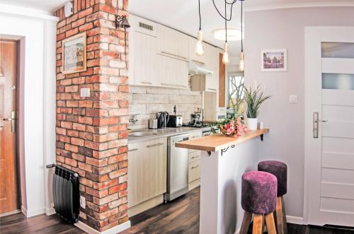 ソポトにあるKlimatyczny apartament Salamandra w Sopocieのキッチン(レンガ造りの煙突、テーブル、椅子付)