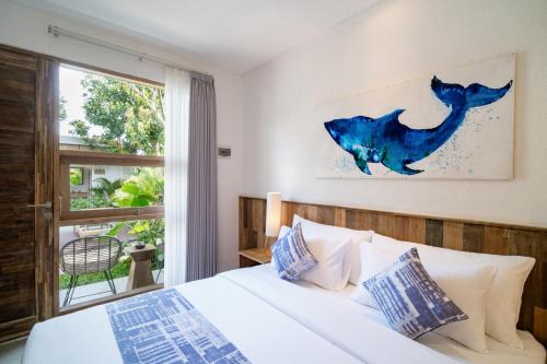 a bedroom with a bed and a large window at Lakubumi Pavilion in Jimbaran