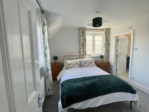 a bedroom with a bed and a white door at Happy Hinwood House, Hampshire! in Stockbridge