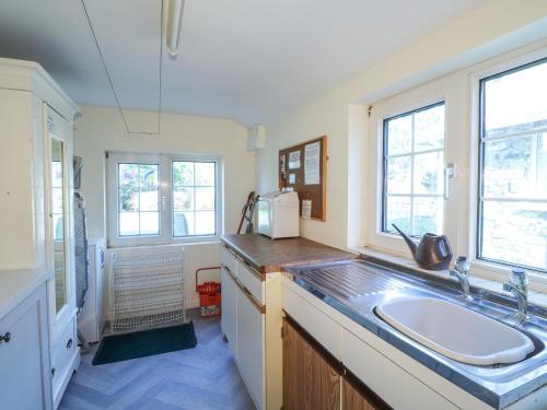 Una cocina con fregadero y dos ventanas. en Meadowlands, en Newport
