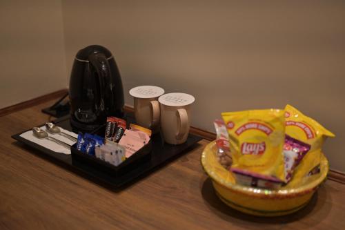 a table with a bowl of snacks and a telephone at Clarks Safari Haridwar in Haridwār