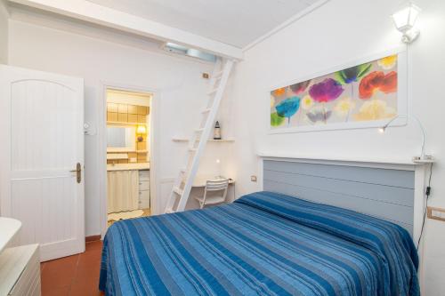a bedroom with a blue bed and a ladder at Casetta di Linda in La Marmorata