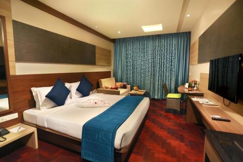 a hotel room with a large bed and a television at Germanus Springs Kodaikanal in Kodaikānāl