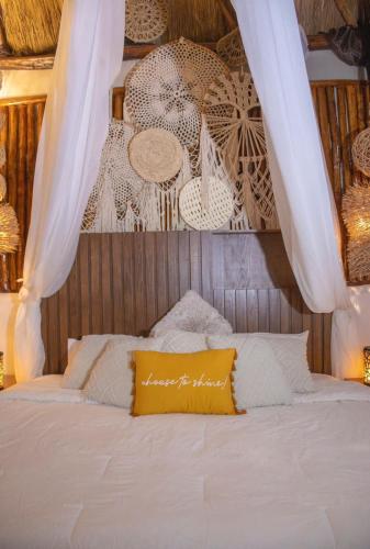 a bed with a yellow pillow on top of it at Aldea Boutique Ommi in Progreso