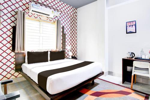 a bedroom with a large bed and a window at Super Townhouse Chandrasekharpur in Bhubaneshwar