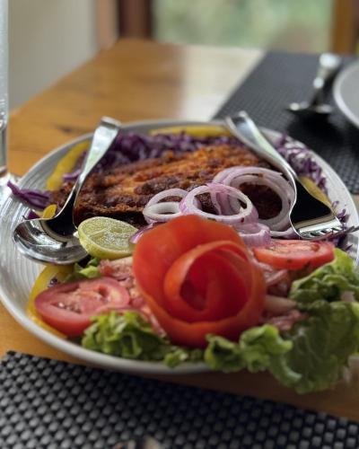 a plate of food with meat and vegetables on a table at Wayanad Silverwoods Forest Resort & Spa in Padinjarathara