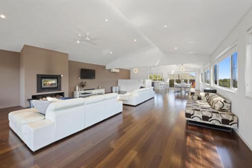 a living room with white furniture and wood floors at Eagles Nest - Merrijig - Sleeps 10 in Merrijig