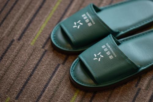 a pair of green flip flops sitting on a table at Kindness Hotel-Jue Ming in Kaohsiung