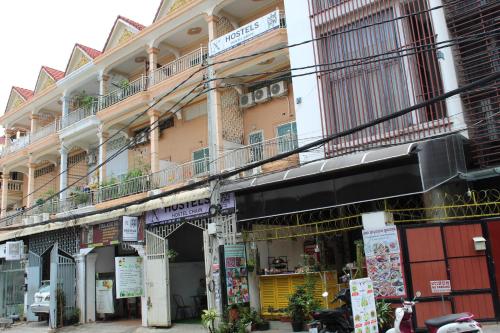 un gran edificio con balcón en una calle en KN HOSTEL & Coffee - Spa, en Phnom Penh