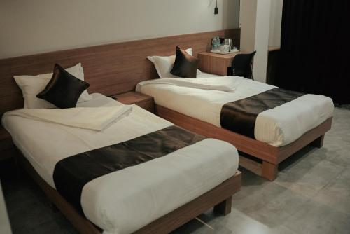 two beds in a hotel room at Hotel Momon in Guwahati