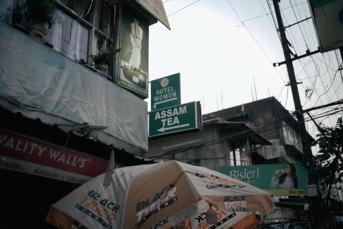 an asian tea sign on a building with an umbrella at Hotel Momon in Guwahati