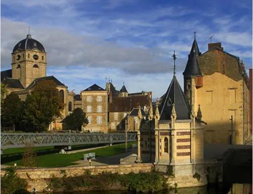 an old castle with a bridge and a tower at Les 3 petites pommes in Alençon