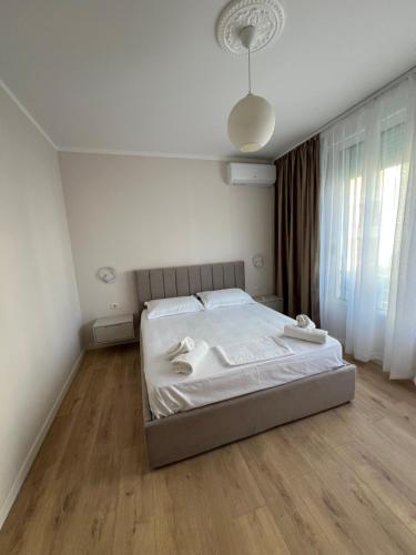 a bedroom with a bed with white sheets at Bellavista Qerret Apartments in Golem