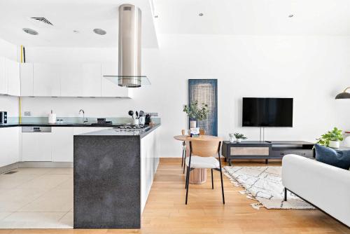 a kitchen and living room with white cabinets and a table at Silkhaus Vacation Homes cozy Studio at Al Bandar Marina with gym in Abu Dhabi