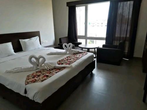a bedroom with a large bed with a large window at Hotel EAST INTERNATIONAL in Tinsukia