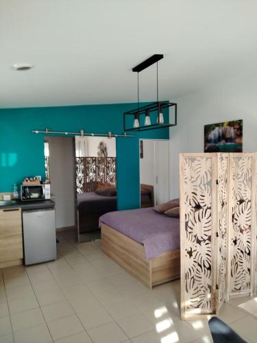 une chambre avec un lit et un mur bleu dans l'établissement La Pépite de l'océan, à Saint-Nazaire