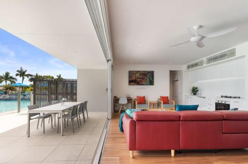 a living room with a red couch and a table at Pool Resort Port Douglas in Port Douglas