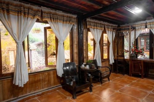 a room with a table and chairs and windows at Mế farmstay in Cao Bằng