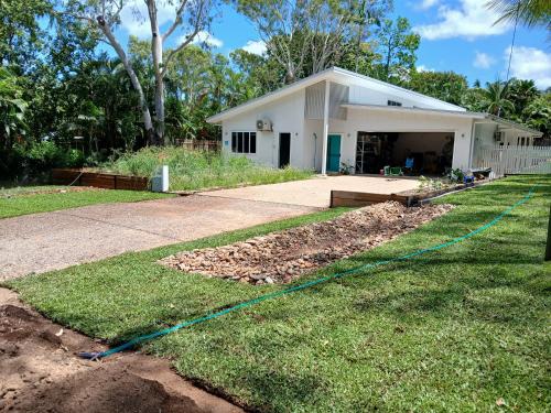 a yard with a hose in front of a house at Rosalita, Picnic Bay in Picnic Bay
