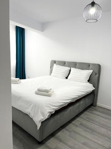 a bed with two towels on it in a bedroom at ONE Apartment in Iaşi