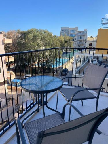 a patio with a table and chairs on a balcony at Swieqi Malaika New Apt 5 in Is-Swieqi