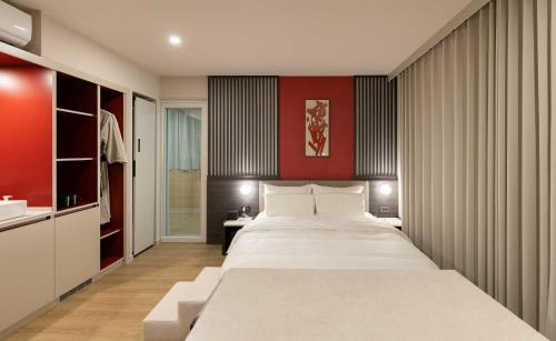 a bedroom with a large bed and a red wall at Koum Ryokan Hotel Gijang by Aank in Busan