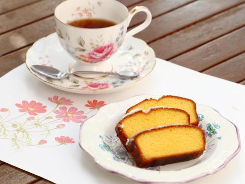 a plate with a piece of cake and a cup of tea at ペンション花多來 in Shima