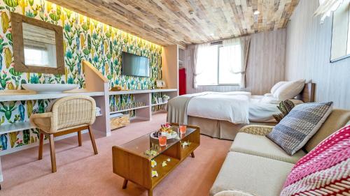 a hotel room with a bed and a living room at Palm Springs Miyakojima Resort in Miyako-jima