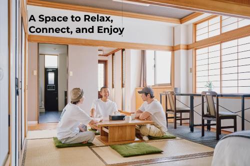 a group of people sitting around a table in a room at Japanese Tradition Hotel Evergreen in Tokyo