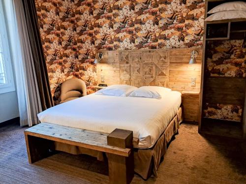 a bedroom with a bed and a wall with flowers at Hôtel de Paris in Besançon