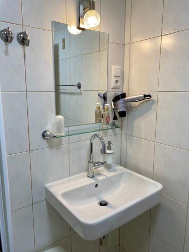 a white bathroom with a sink and a mirror at Haus Salzkristall in Obertraun