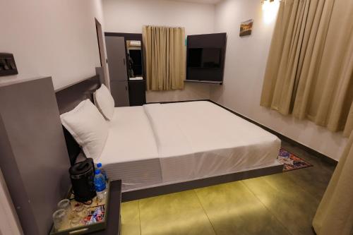a bedroom with a large white bed in a room at The Cozy Winterfell in Munnar