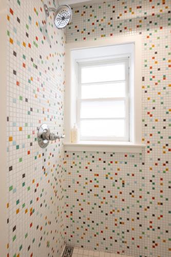 a bathroom with a window and a mosaic wall at Little Mod Hotel at the University in Charlottesville