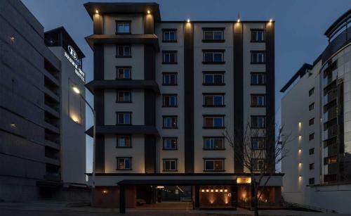 a tall building with lights on the side of it at Koum Ryokan Hotel Gijang by Aank in Busan