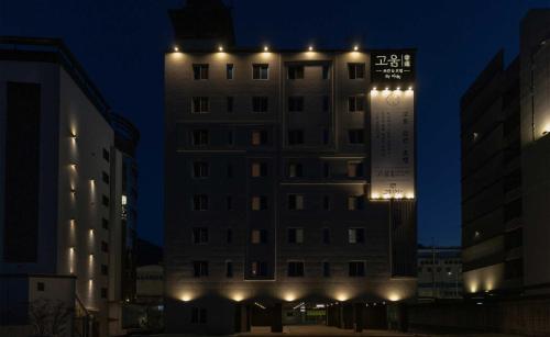 a tall building with lights on it at night at Koum Ryokan Hotel Gijang by Aank in Busan