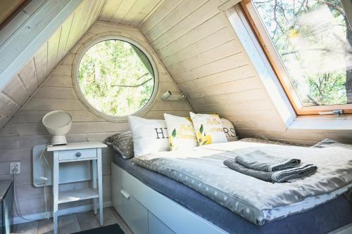 Stare CzapleにあるJezioro Marzeń na Kaszubachの小さな家のベッド1台 窓付