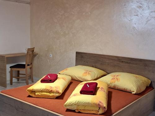 two beds with yellow and red pillows on them at Penzion Motylek in Vřesina