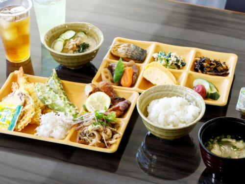 a table with three plates of food and a drink at Miyazaki Lions Hotel in Miyazaki