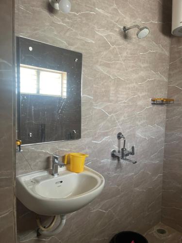 a bathroom with a sink and a mirror at Kuteeram - Create Memories in Secunderabad