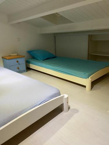 - une chambre avec 2 lits et une table de nuit dans l'établissement Ambassades du soleil 4, au Cap d'Agde