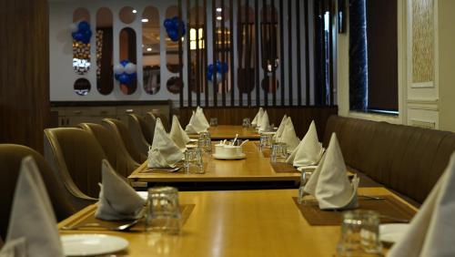 a row of tables in a restaurant with napkins at Yu turn in Greater Noida