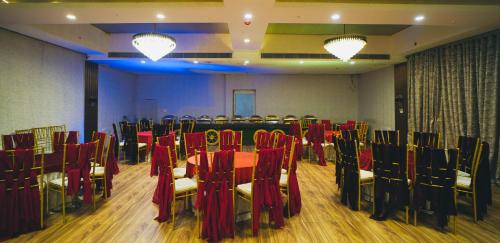 a conference room with red chairs and a table at Yu turn in Greater Noida
