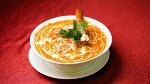 a bowl of soup on a plate on a red table at Yu turn in Greater Noida