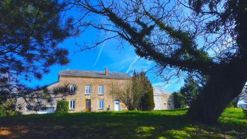 ein altes Backsteinhaus auf einem Hügel mit einem Baum in der Unterkunft Une histoire de famille in Écordal