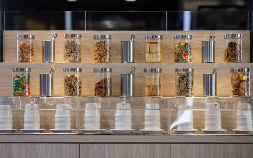 a row of jars filled with food on a counter at Kindness Hotel-Qixian in Kaohsiung